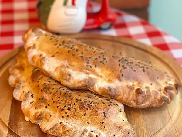Złociste calzone na drewnianej desce